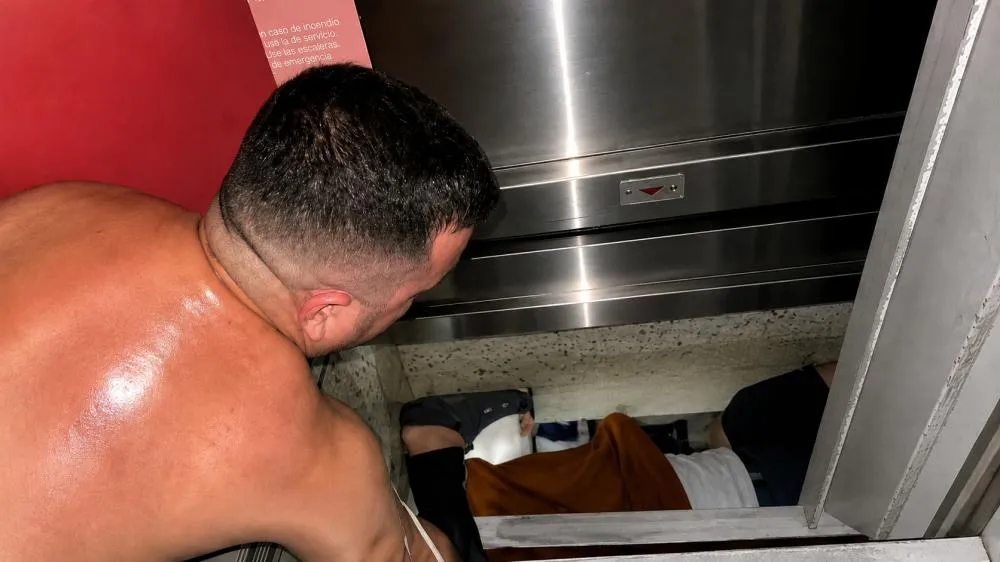 Homem na tentativa de abrir elevador. Foto: Arquivo pessoal